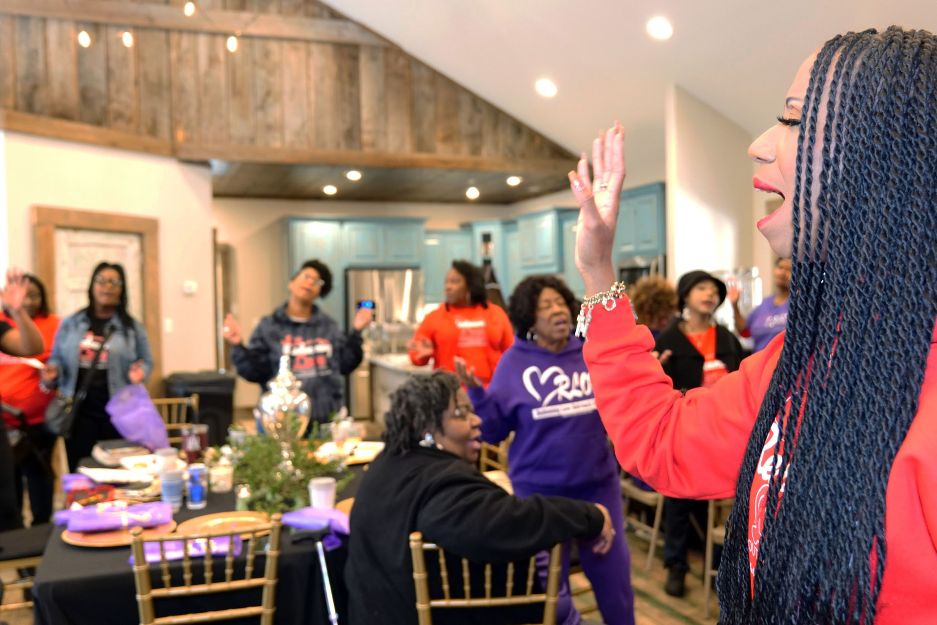 Women worshipping with raised hands during a Daughters of Promise gathering.