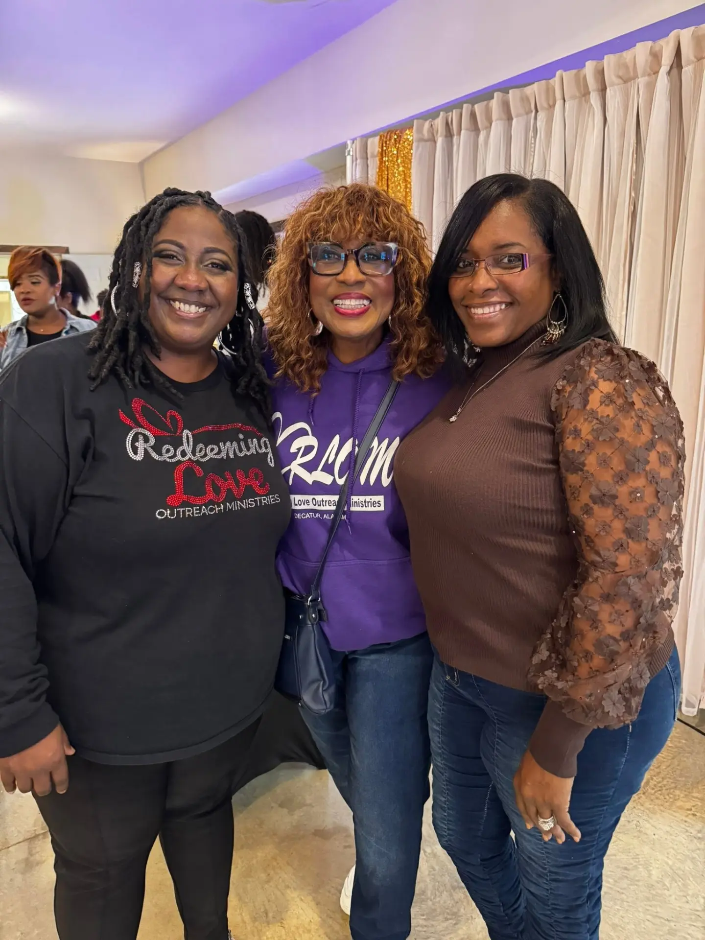 Three ministry leaders smiling together at a Daughters of Promise gathering.