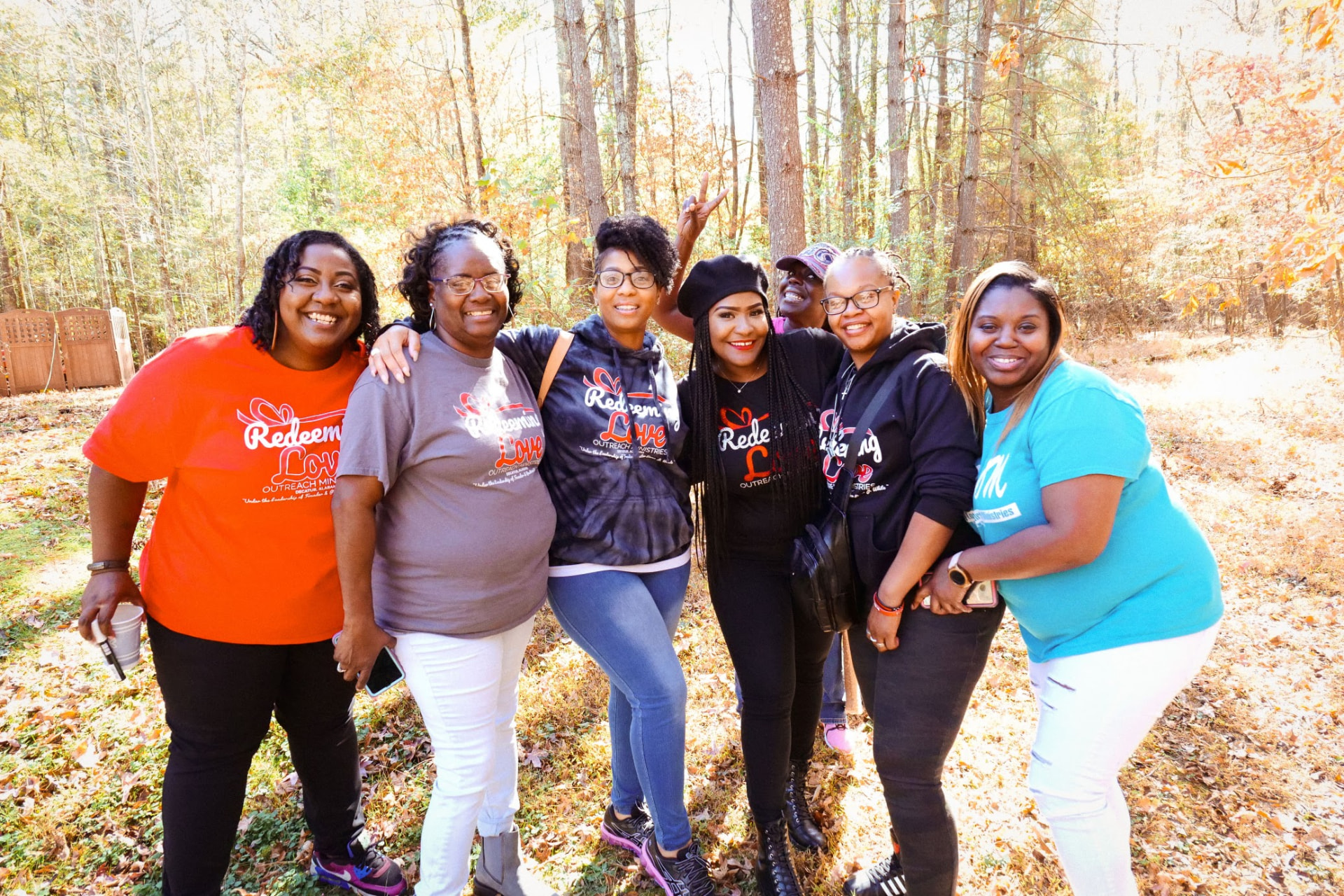 Ministry sisters posing together among autumn trees during a Daughters of Promise retreat.